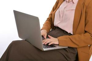 Close up of a business woman using laptop on her lap while sitting photo