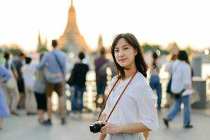 Portrait young beautiful asian woman smiling while travel at Wat Arun sunset view point, Bangkok, Thailand. photo