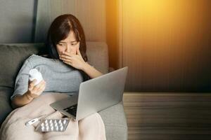 Sick asian woman with medicine having video call conference medical app in telehealth on laptop. Healthcare, technology and people concept photo