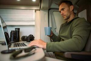 Men Working While Traveling in His Camper Van Motorhome photo