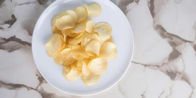 Delicious potato chips in a deep white plate Ai generated photo