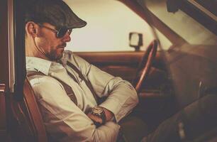 Retro Looking Men Seating Inside Classic Car photo