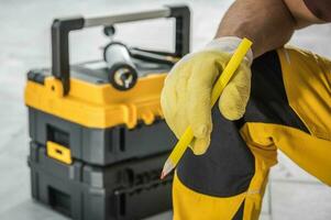 Contractor Worker with Pencil in His Hand and Tools Box photo