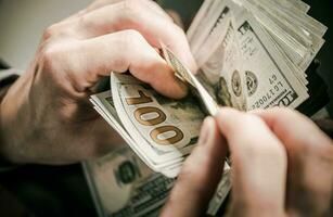 Man Counting One Hundred Dollar Bills. photo