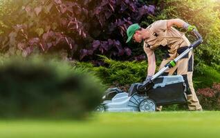 Garden and Landscaping Worker Mowing  Backyard Lawn photo