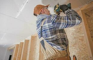 construcción contratista adjuntando paneles de yeso elementos a el casa techo foto