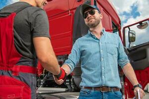 Happy and Satisfied Truck Driver Shaking His Mechanics Hand photo