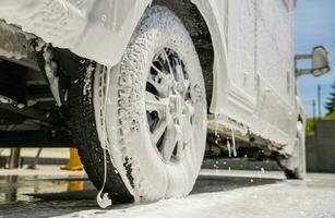 RV Motorhome Camper Van Covered by Active Washing Foam photo