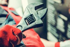 Industrial Worker with Large Adjustable Wrench in His Hand photo