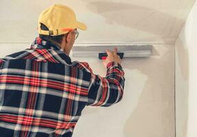 Construction Finishing Worker Patching Drywall photo