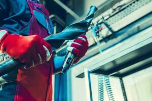 Industrial Worker with Lathe Drill Bits in His Hands photo