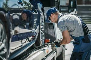 remolcar camión conductor asegurando cargado coche para seguro entrega foto