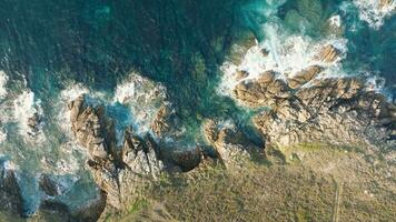 pássaro olho Visão sobre espumoso ondas espirrando em rochoso costa dentro cabo de san Adriano, Espanha - zangão tiro video