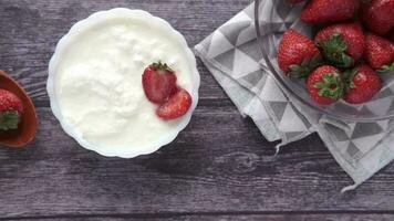 frische Erdbeeren und Joghurt in einer Schüssel auf dem Tisch video