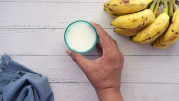 mão escolher uma vidro do leite e banana em mesa video