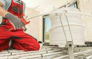 HVAC Worker Cutting Radiant Floor Heating Pipeline Using Tube Slicer photo