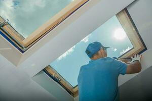 Painter Covering the Roof Window with Painter's Tape photo