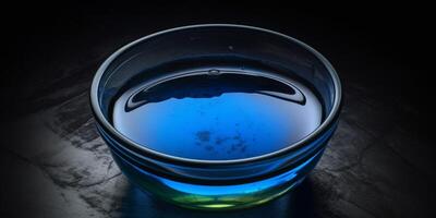 Small glass bowl with blue liquid in it photo