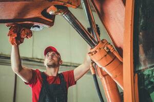 Heavy Equipment Mechanic Performing Excavator Maintenance photo