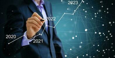 Man's hand pointing graph of success in 2022 year. Growing business concept photo