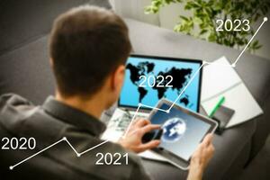 Man's hand pointing graph of success in 2022 year. Growing business concept photo