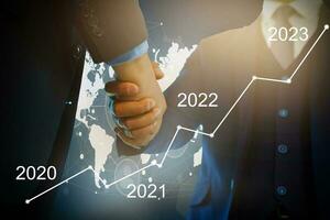 Man's hand pointing graph of success in 2022 year. Growing business concept photo