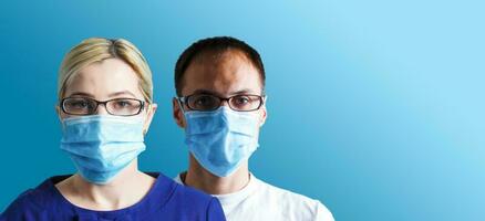 man and woman with face masks looking at camera, corona virus concept. photo