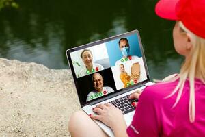 Cropped image of young woman using laptop for video conference at home photo