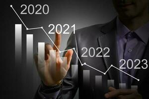 Man's hand pointing graph of success in 2021 year. Growing business concept photo