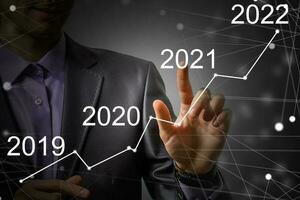 Man's hand pointing graph of success in 2021 year. Growing business concept photo