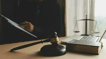 Business and lawyers discussing contract papers with brass scale on desk in office. Law, legal services, advice, justice and law concept picture with film grain effect video