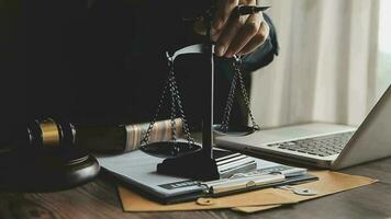 Business and lawyers discussing contract papers with brass scale on desk in office. Law, legal services, advice, justice and law concept picture with film grain effect video