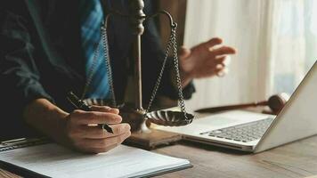 Business and lawyers discussing contract papers with brass scale on desk in office. Law, legal services, advice, justice and law concept picture with film grain effect video