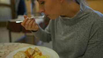 mujer es teniendo almuerzo en un cafetería. ella come pescado y machacado patatas video