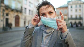 Pandemie Schutz von das covid-19 Coronavirus. Porträt von ein Frau im ein Mantel, Brille und ein schützend medizinisch Maske. Brille Nebel oben von Atem video