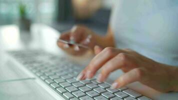 hembra manos mecanografía crédito tarjeta número en computadora teclado. mujer haciendo en línea compra. en línea pago servicio. cerca arriba de mujer manos sostener crédito tarjeta y utilizando computadora para en línea compras video