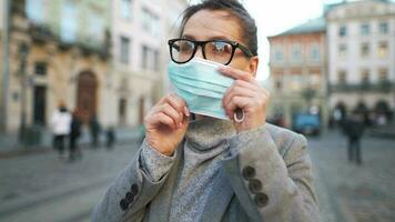 pandémie protection de le covid-19 corona virus. portrait de une femme dans une manteau, des lunettes et une protecteur médical masque. des lunettes brouillard en haut de souffle video