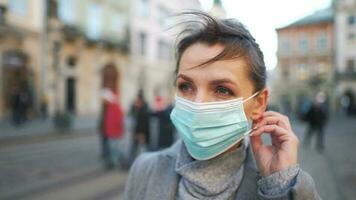 pandemisch bescherming van de covid-19 coronavirus. portret van een vrouw in een jas, bril en een beschermend medisch masker. bril mist omhoog van adem video