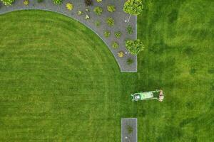 Landscaping Worker Trimming Backyard Grass Using Electric Mower photo