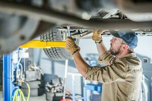 Car Undercarriage Repair Performed by Professional Mechanic photo