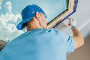 House Renovation Worker Painting the Ceiling in White photo