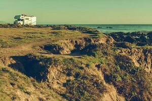 Recreational Vehicle Alone on Hilly Ocean Coast photo