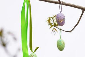 Three Easter eggs with branches on sky background photo