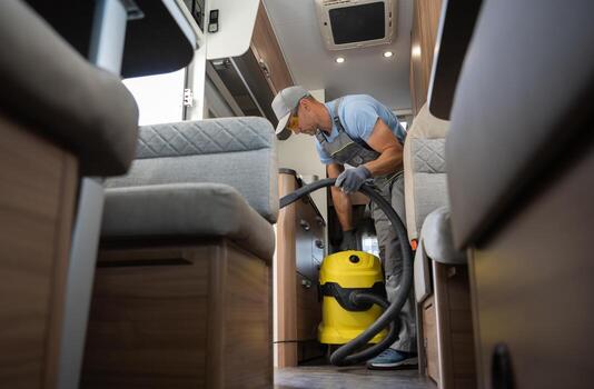 trabajador con industrial grado vacío limpiador limpieza casa rodante camper camioneta interior foto