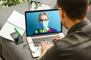 Young Female Doctor Video Chatting On Laptop In Clinic photo