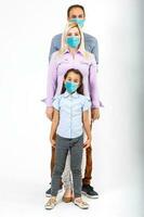 family in protective masks quarantined. Normal life with coronavirus. Lifestyle COVID-19. Quarantine virus protection sterility home together heart symbol photo