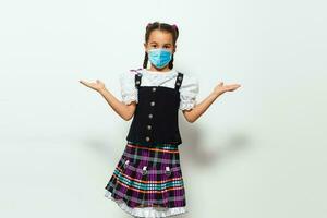 Masked child - protection against influenza virus. Little Caucasian girl wearing mask for protect pm2.5. baby on a gray background with copy space. epidemic, pandemic. photo