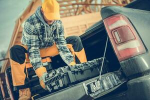 Worker Preparing His Tools on the Pickup Cargo Section photo