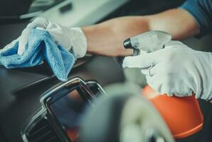 Worker Cleaning Car Dashboard photo