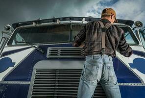 comercial conductor comprobación camión parabrisas limpiaparabrisas en su vehículo foto